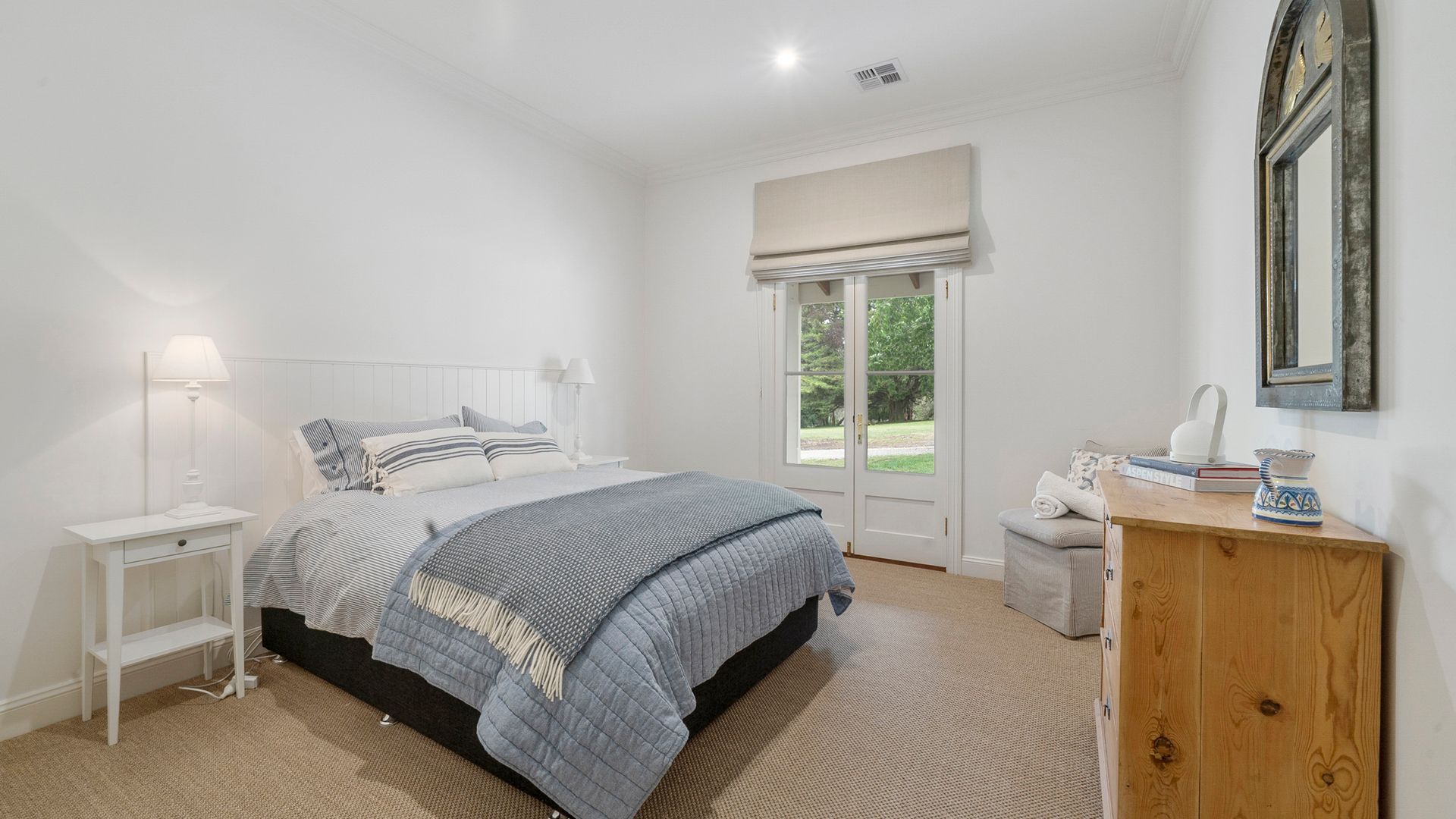 Un dormitorio con cama, mesitas de noche, cómoda y ventana con vistas.