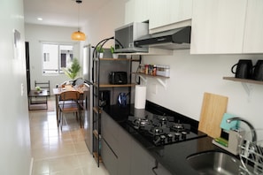 Une cuisine moderne équipée d’une cuisinière à gaz, d’un four à micro-ondes et de placards.
