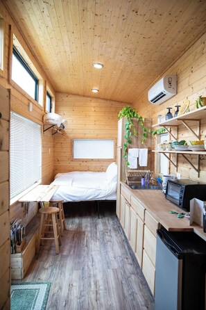 Un accogliente chalet in legno con un letto a castello, angolo cottura e un piccolo spazio ristoro.