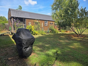 A residential property with a covered outdoor grill, a brick house, and a well-maintained garden with various plants and flowers. - Spacious 4BR house tranquil lakeview w boat launch beach access/park extra prkng (Jacksonville)