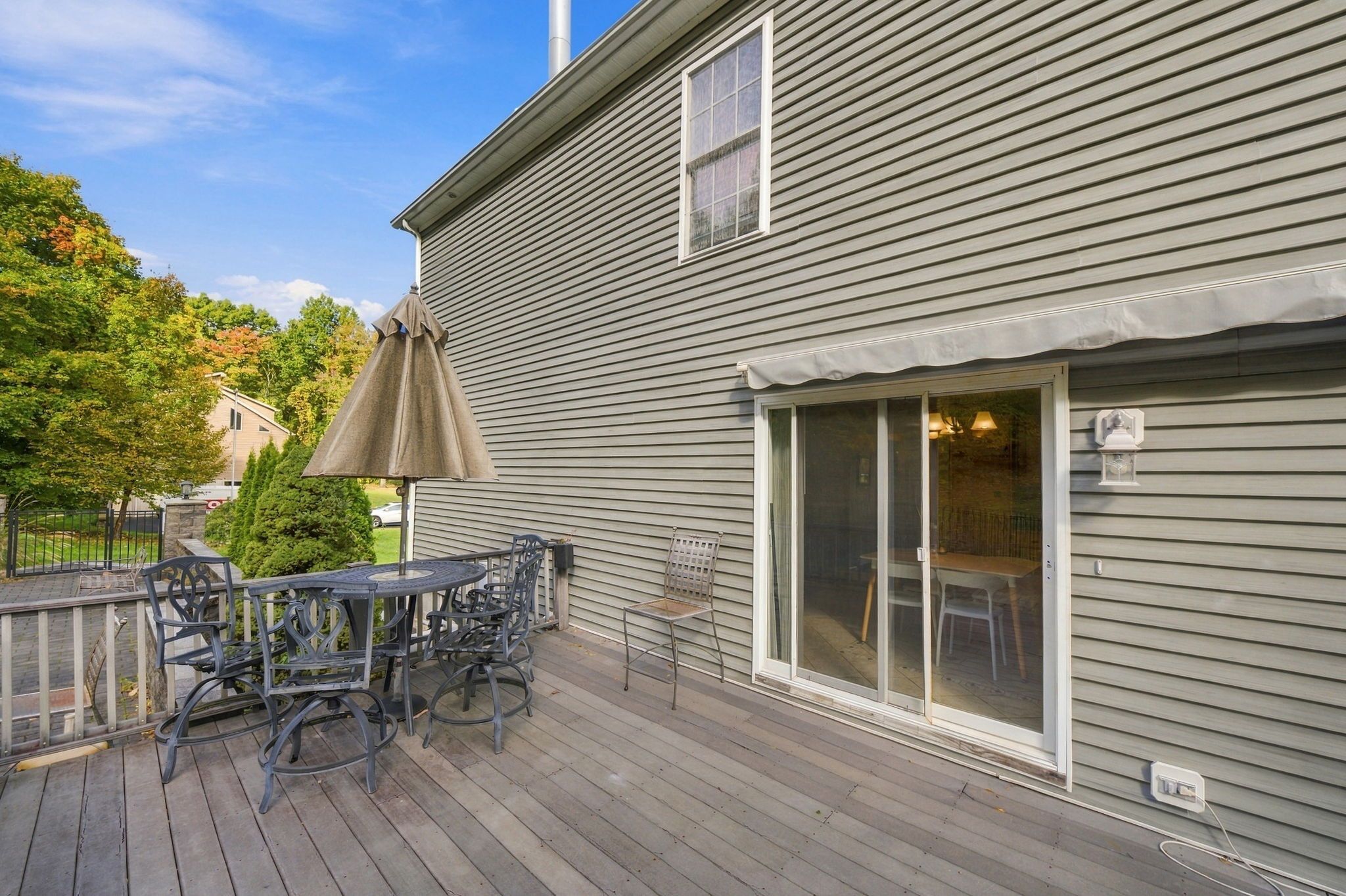 A deck with outdoor furniture and a covered umbrella.