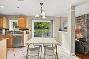 A modern kitchen with a dining area, a stone fireplace, and a view of the outdoors. - Hudson Landing - Fireplace & Catskills Retreat (Saugerties)