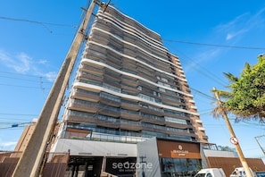 A multi-story hotel with a modern design, featuring balconies on each floor, a beach club sign, and a storefront with a sign that reads 'seozone'. - Apt. in Condo. w/ Pool & Beach View Dlo0606 (Salvador)
