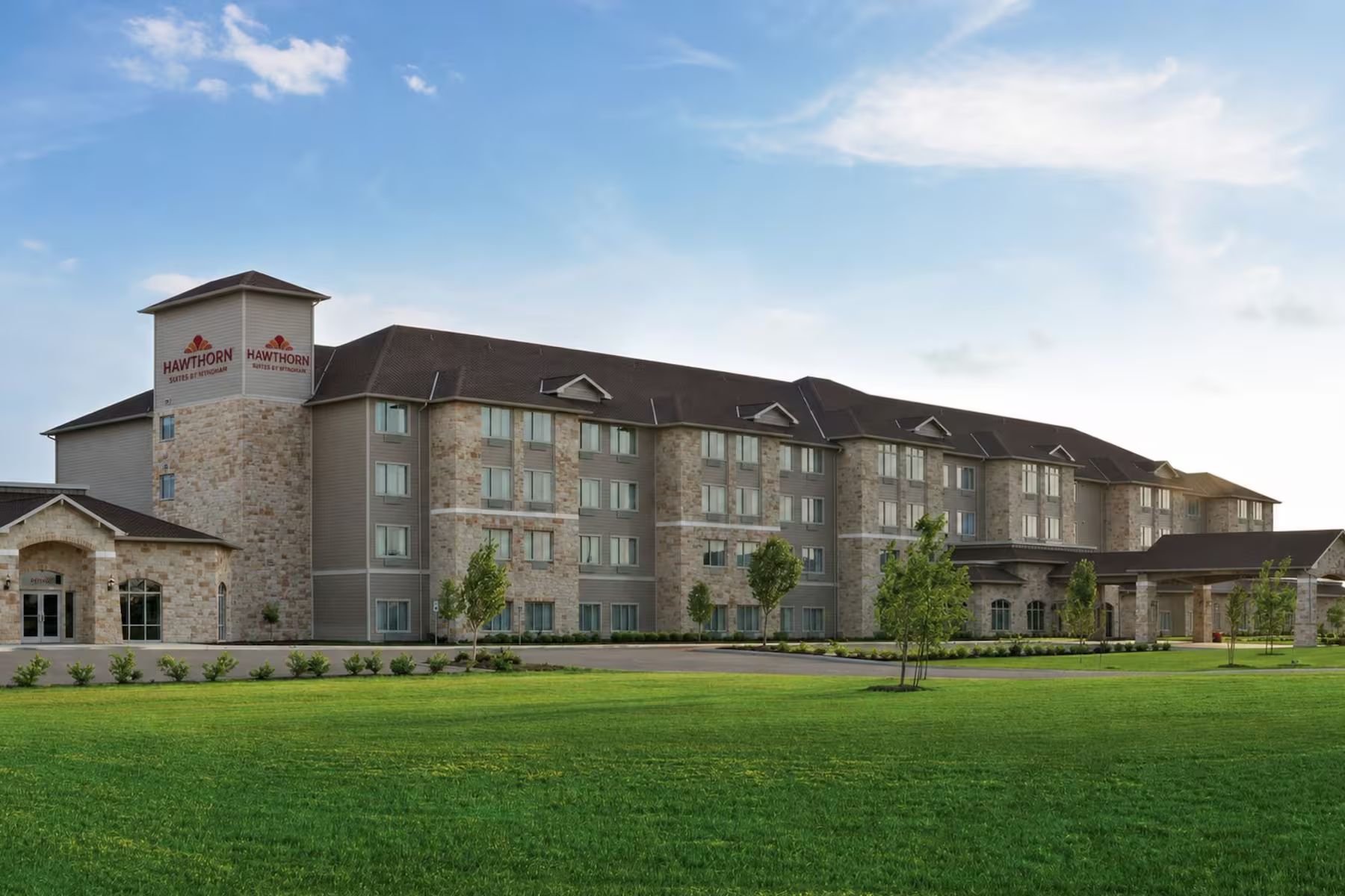 A multi-story hotel with a stone facade, multiple windows, and a flat roof.