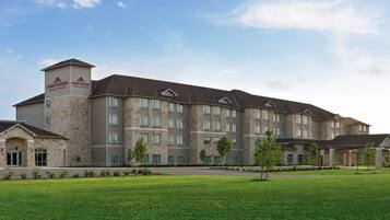 A multi-story hotel with a stone facade, multiple windows, and a flat roof.