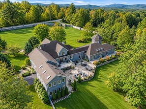 Une grande maison à deux étages, dotée d’un vaste patio et d’une tour.