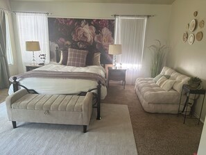 A bedroom with a bed, a bedside table, a chair, a sofa, and a large floral wall mural. - Elegant 4-bedroom 2,5 bath furnished & renovated house in beautiful Newbury Park (Thousand Oaks)