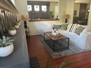 A living room with a sofa, coffee table, and potted plants. - Elegant 4-bedroom 2,5 bath furnished & renovated house in beautiful Newbury Park (Thousand Oaks)