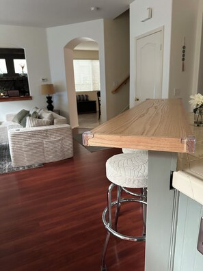 A modern kitchen with a wooden countertop and a bar stool. - Elegant 4-bedroom 2,5 bath furnished & renovated house in beautiful Newbury Park (Thousand Oaks)