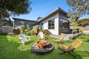 A modern house with a fire pit, outdoor seating, and a well-maintained lawn. - Links & Leisure Retreat - Relaxed Coastal Stay (Anglesea)