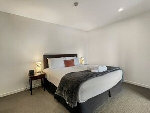A hotel room with a bed, bedside tables, and a lamp. - Cosy Alpine Lakeview Suite for Couples (Queenstown)