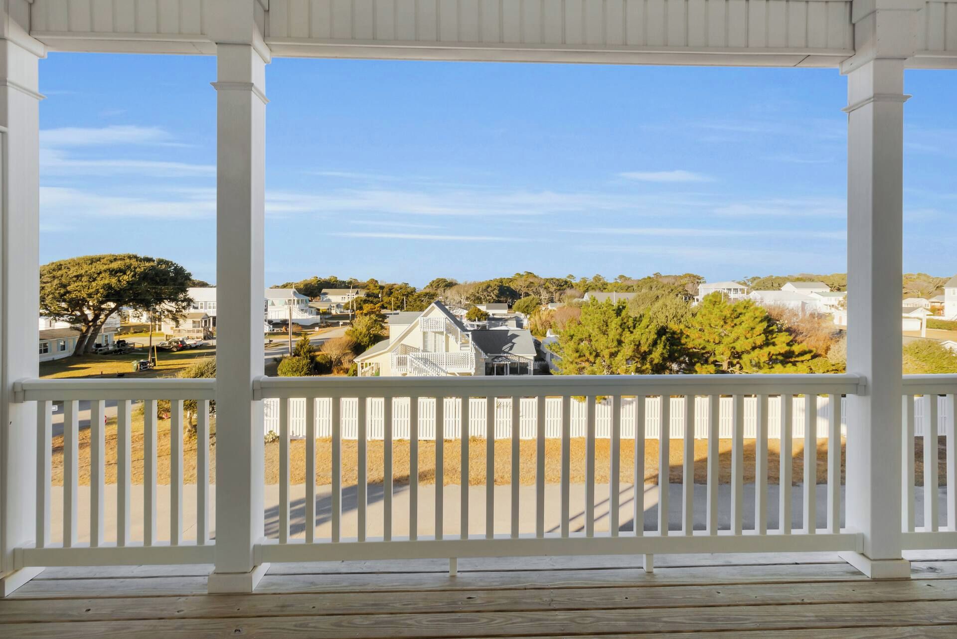 A covered porch with a view of a residential area.