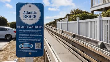 A sign for Atlantic Beach North Carolina, instructing beach walkers to collect trash and return it to the stand.