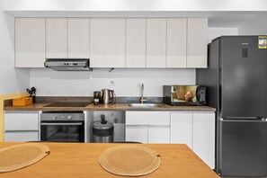 Una cocina moderna con electrodomésticos de acero inoxidable, microondas y horno empotrado.