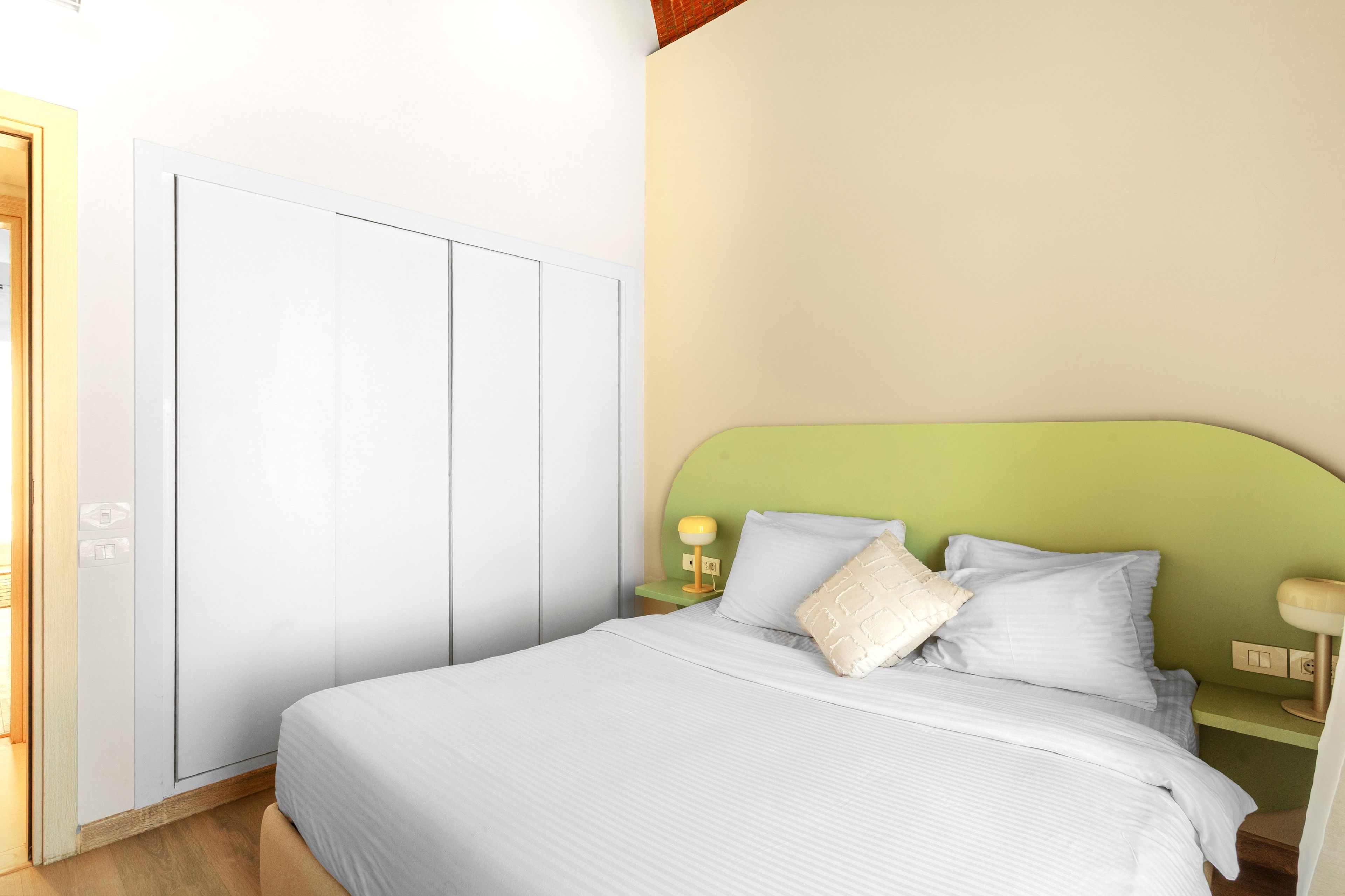 Una camera da letto con un letto, un comodino, una lampada e un armadio.