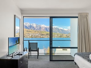 A hotel room with a large sliding glass door leading to a balcony with a mountain view. - Alpine Lakeview Villa, 3 Bed, Queenstown (Queenstown)