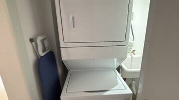 A compact laundry area with a front-loading washer and dryer.