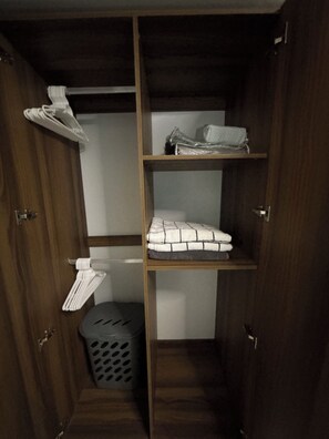 A wooden wardrobe with multiple shelves, a hanging rack, and a laundry basket. - 3-bedroom / 2 bathroom apartment in superb San Marcos with AC, close to airport! (San Marcos)