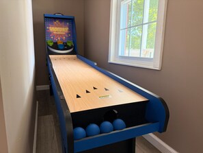 A shuffleboard table with a 'VICTORY' game in a room with a window and a door.