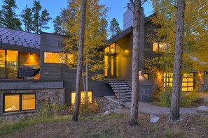 A modern house with a stone facade, large windows, and a staircase leading to the entrance. - NEW Cloud 9 Cabin in Warrior's Mark near Peak 9 & 10. Amazing Views & Mtn Access! (Breckenridge)