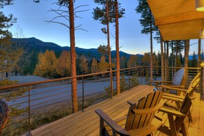 A wooden deck with chairs overlooking a river and mountains. - NEW Cloud 9 Cabin in Warrior's Mark near Peak 9 & 10. Amazing Views & Mtn Access! (Breckenridge)