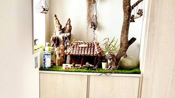 A room with a built-in cabinet featuring a miniature forest scene with trees, branches, and a small house.