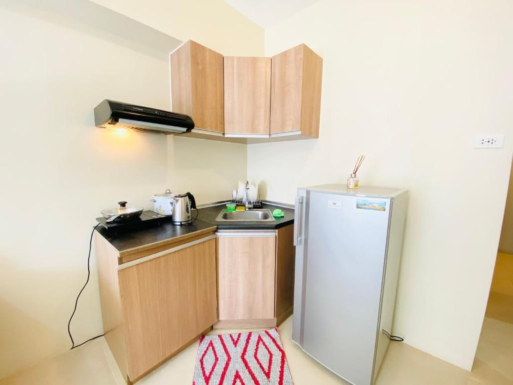 Eine kleine Küche mit Holzausstattung, inklusive Backofen, Spüle und Kühlschrank.