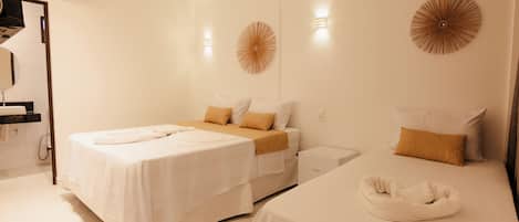 A hotel room with a bed, bedside tables, a mirror, and a wall-mounted air conditioner.