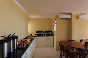 Una cocina con mesas de buffet, que incluyen una parrilla y diversas opciones de comida.