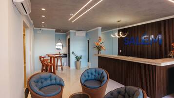 A reception area with a 'SALÉM' sign, wicker chairs, a small table, and a potted plant.