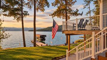 Une propriété au bord du lac, dotée d’une terrasse, d’un drapeau américain et d’un quai.