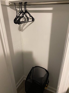 A closet with a hanging rod and a mesh storage bag. - Cozy and Comfy "Away from Home" (Pine Bluff)