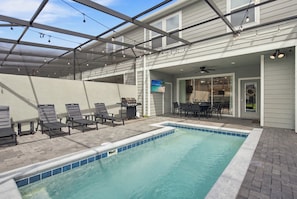 A covered outdoor swimming pool with lounge chairs and a barbecue grill. - Super Mario, Avengers & Harry Potter Rooms (Davenport)