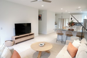 A modern living room with a flat-screen TV, a round wooden coffee table, and a sofa with cushions. - Immerse Yourself in Sedona’s Natural Beauty. (Sedona)