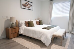 A bedroom with a bed, bedside tables, a lamp, a window with curtains, and a wall-mounted picture. - Immerse Yourself in Sedona’s Natural Beauty. (Sedona)