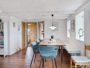 Ein stilvoller Essbereich mit Holztisch, blauen Stühlen und einer Pendelleuchte.