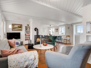 Ein modernes Wohnzimmer mit Kamin, Sitzecke und Bücherregal.