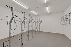 A clinical room with medical equipment, including IV stands and monitors, on a white floor and walls. - Book 1 get 2, Central Apartments - Walk to Stadium (Christchurch)