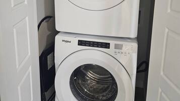 Dos lavadoras de carga frontal Whirlpool apiladas en un cuarto de lavado.