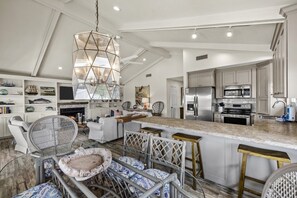 A spacious kitchen with a high ceiling, modern appliances, and a central island with stools.