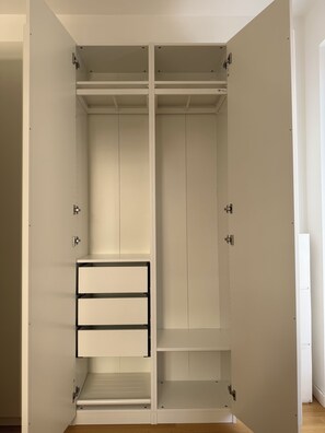 Un vestidor amplio con puertas corredizas, que incluye varios estantes y cajones.