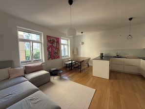A modern apartment with a dining area, kitchenette, and a sofa. - Modern, Fully Furnished City Apartment - 5 minutes from downtown (München)