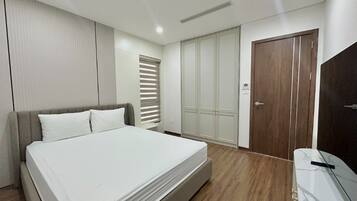 Un dormitorio con cama, armario y escritorio.