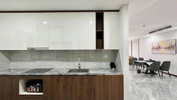 A modern kitchen with a marble countertop, wooden cabinetry, and a built-in sink.