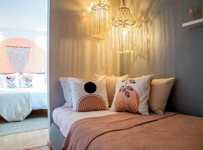 A bedroom with a bed, decorative pillows, a hanging light fixture, and a view of another room. - Walk Polanco, luminous, safe, lots of space & love (Mexico City)
