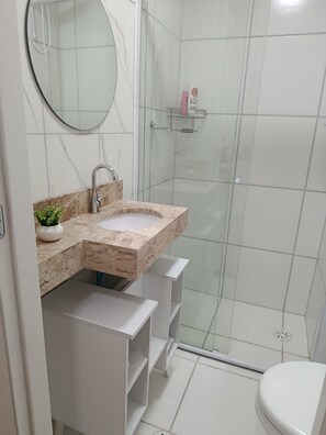 A bathroom with a sink, mirror, and shower. - New Studio República Copan- Mackenzie (São Paulo)