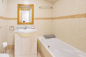 A bathroom with a white sink, mirror, and bathtub. - Manilva Playa with Sea view for 5, Manilva, Spain (Manilva)