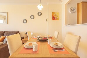 A dining area with a wooden table, chairs, and a variety of dishes. - Manilva Playa with Sea view for 5, Manilva, Spain (Manilva)