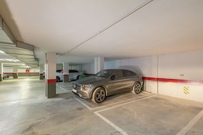 A parking garage with a grey car parked in a designated space. - Manilva Playa with Sea view for 5, Manilva, Spain (Manilva)