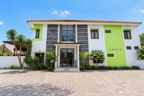 A modern two-story house with a tiled roof, large windows, and a paved entrance. - Hotel O near Monumen Jogja Kembali (Ngaglik)